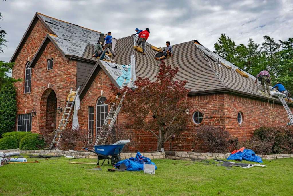 Roofing crew replacing an asphalt shingle roof on a brick home in Texas