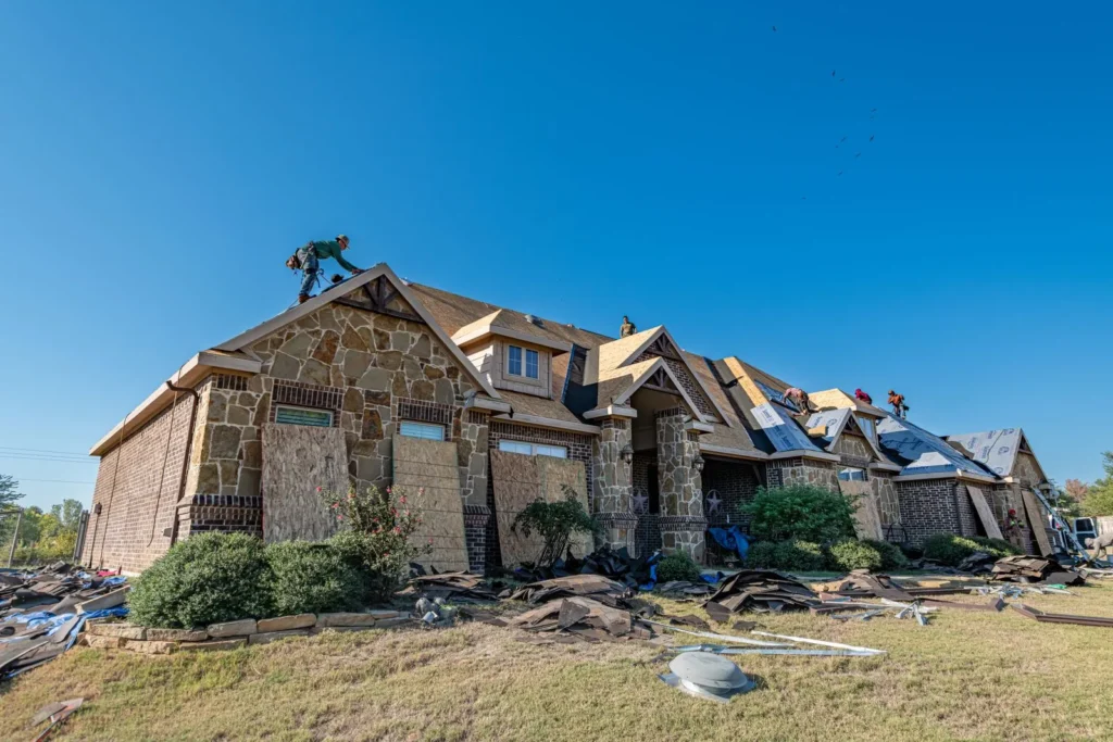 New asphalt shingle roof installation on a stone and brick home in Texas