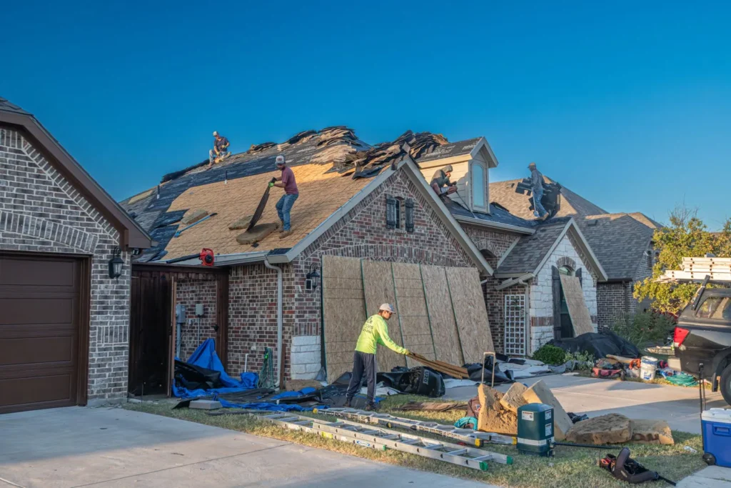 Roof tear-off and replacement in progress on a brick home