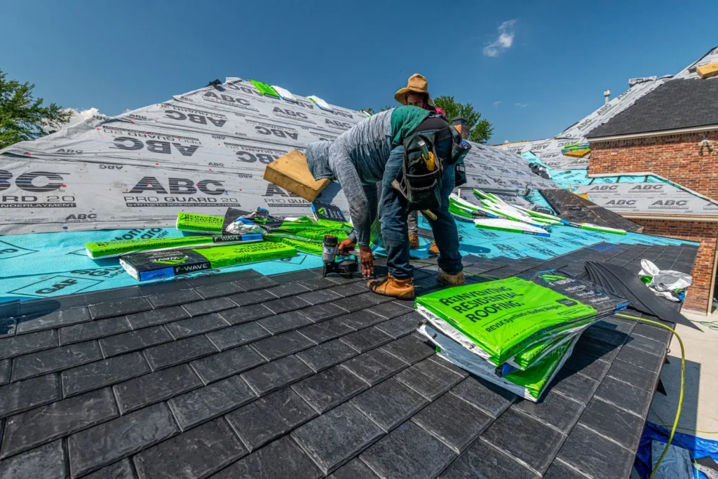 Roofer working with bundles of asphalt shingles on a new roof