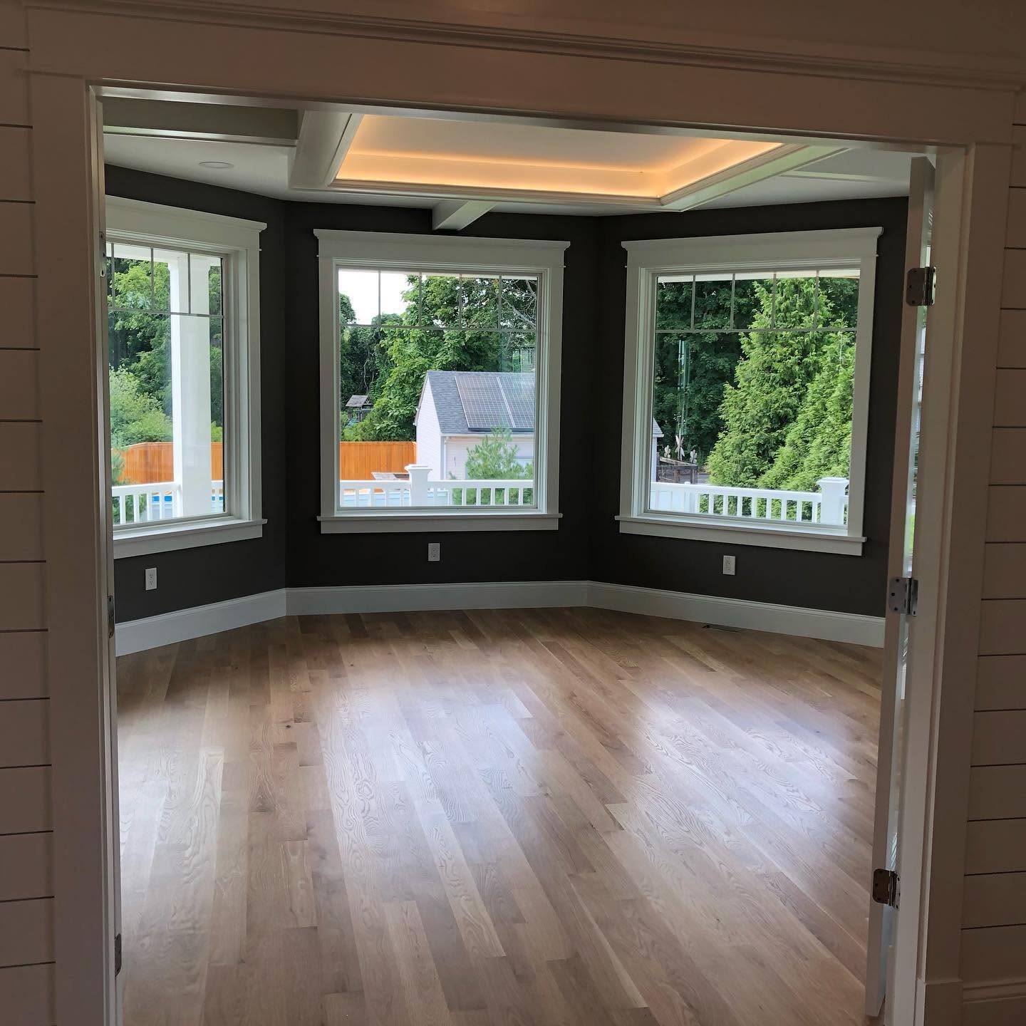 Bay window with painted white trim and hardwood floor