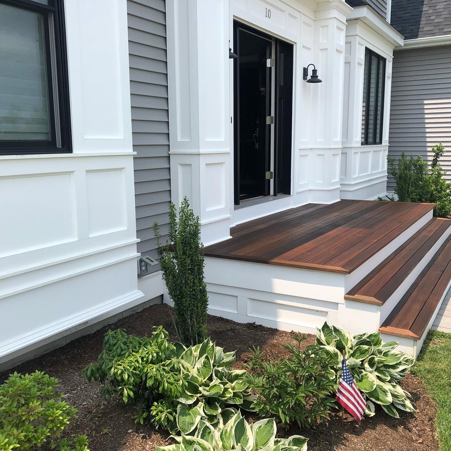 Finished mahogany porch steps against white painted trim