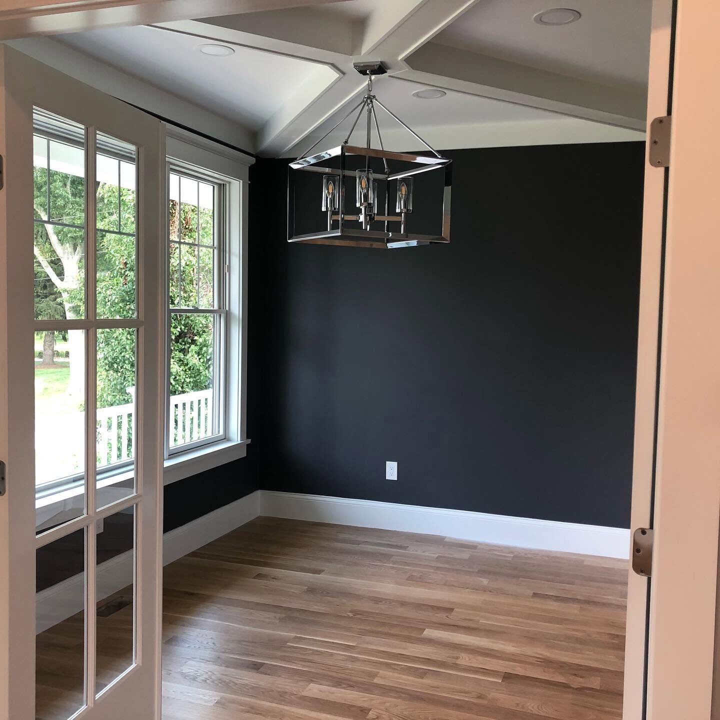 Dining room painted deep navy with white coffered ceiling