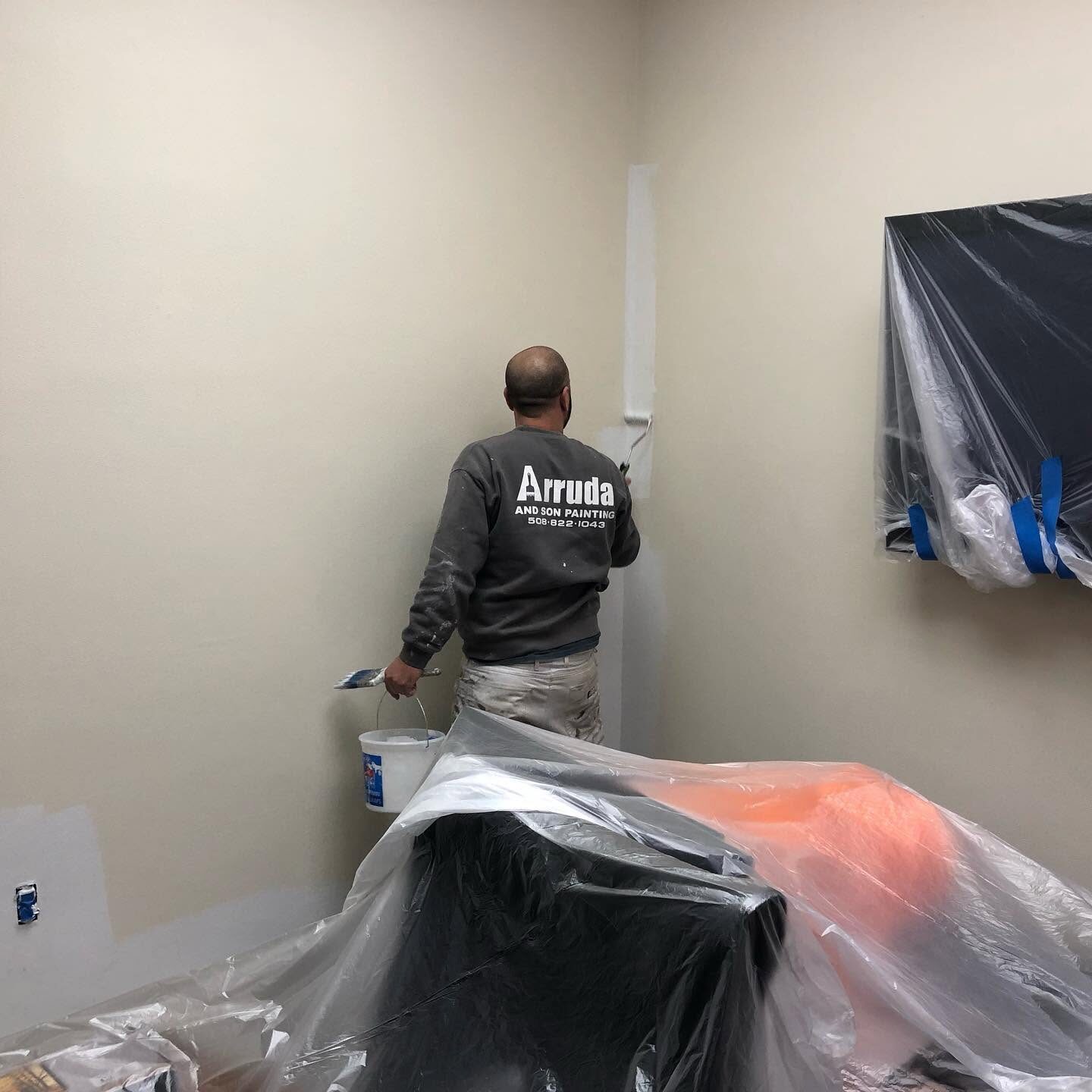 Val Arruda and Son painter cutting in an office wall