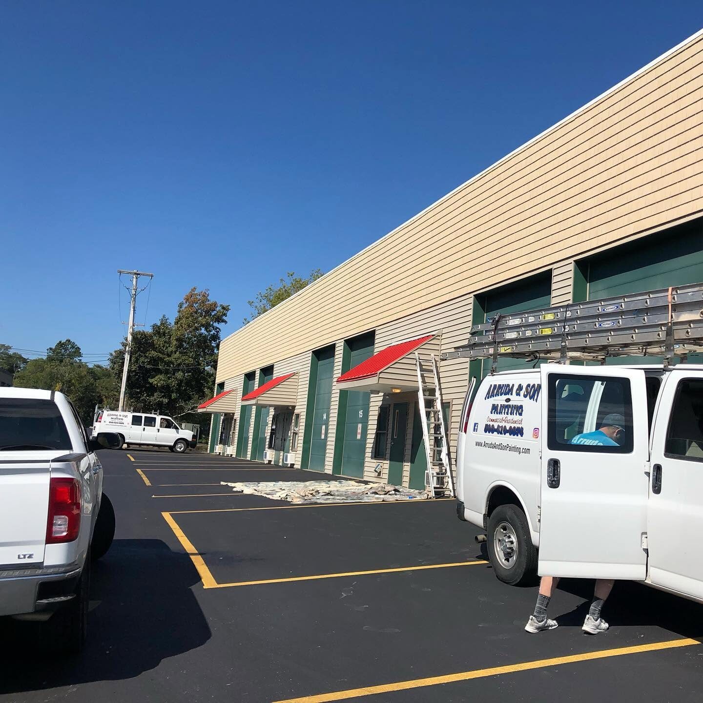 Val Arruda and Son service vans at a commercial plaza repaint