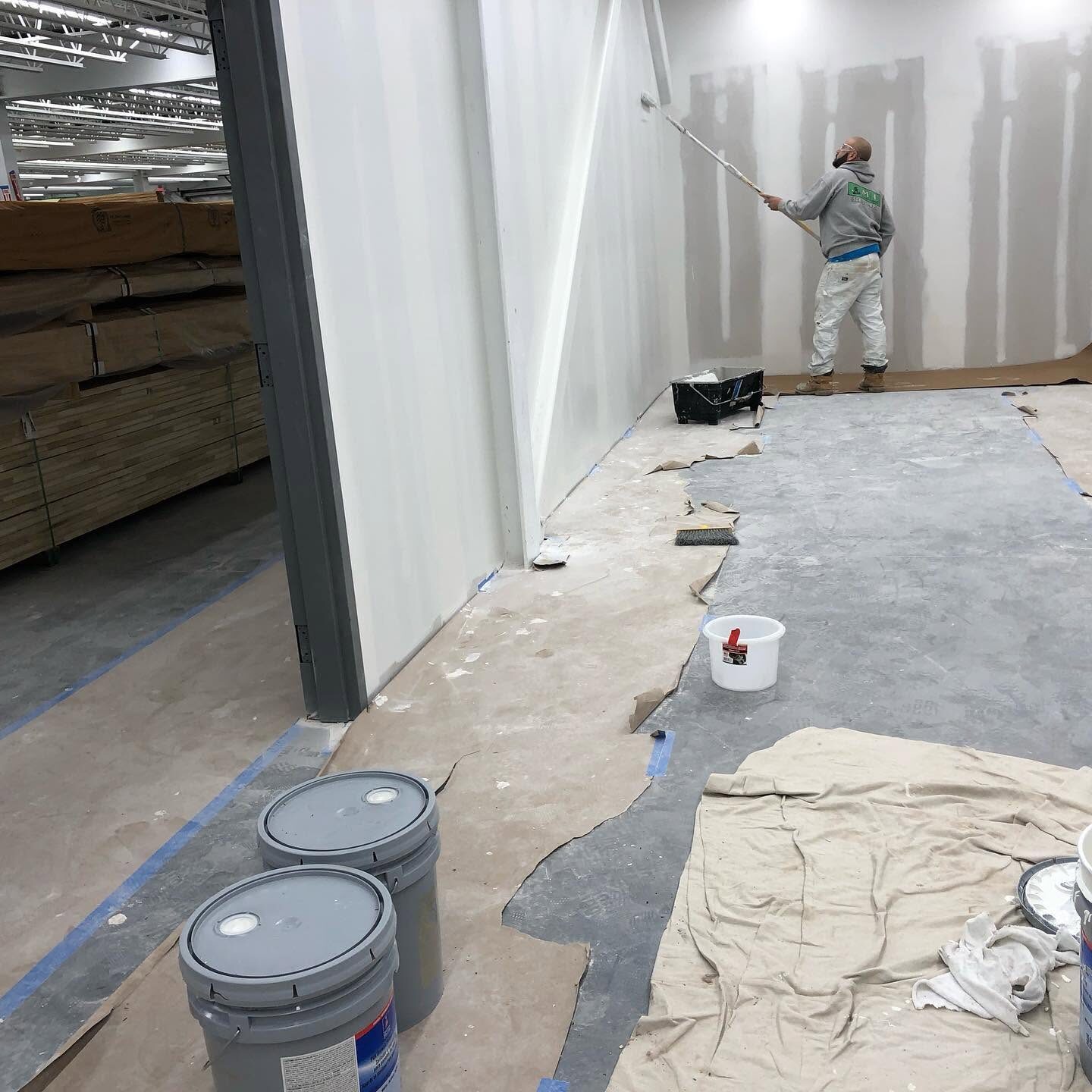 Painter rolling a finished sheetrock wall in a commercial space