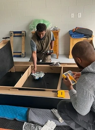 Two P.R. Handy Movers crew members assembling a bed frame
