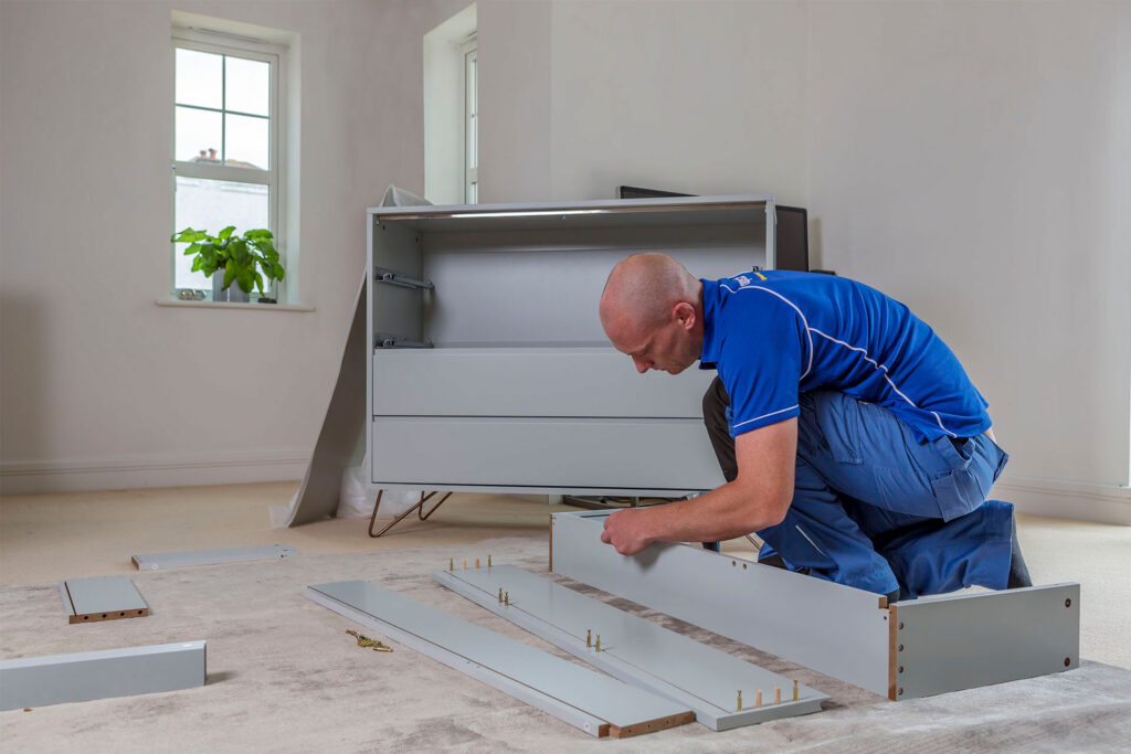 Handyman assembling a flat-pack cabinet on the floor