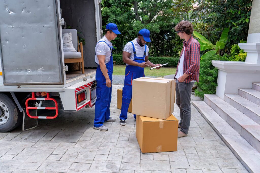 Movers reviewing the moving plan with a customer next to the truck