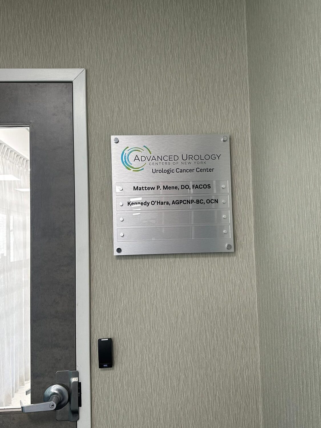 Brushed suite sign beside the door for Advanced Urology