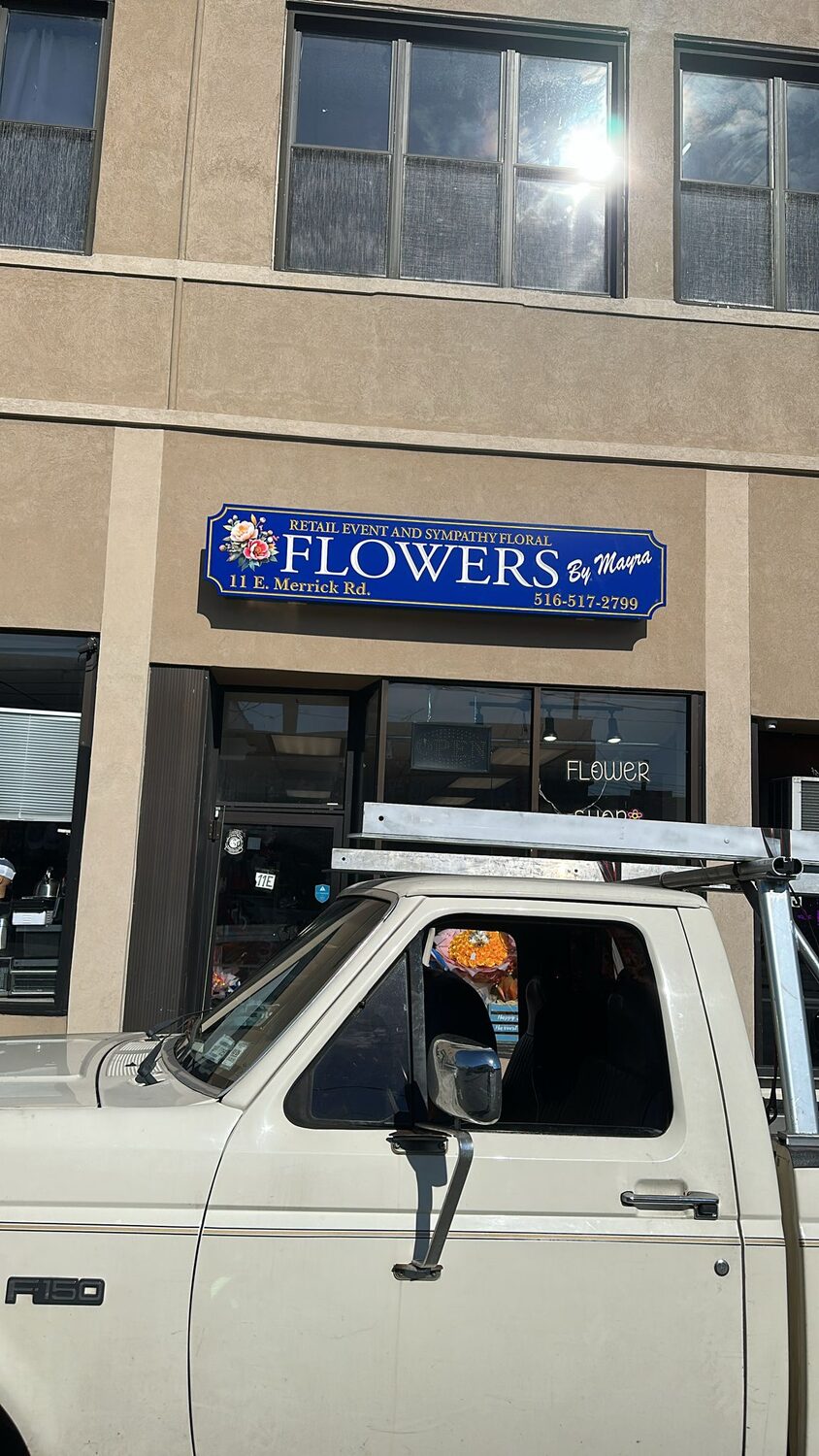 Carved storefront sign for Flowers by Maypa