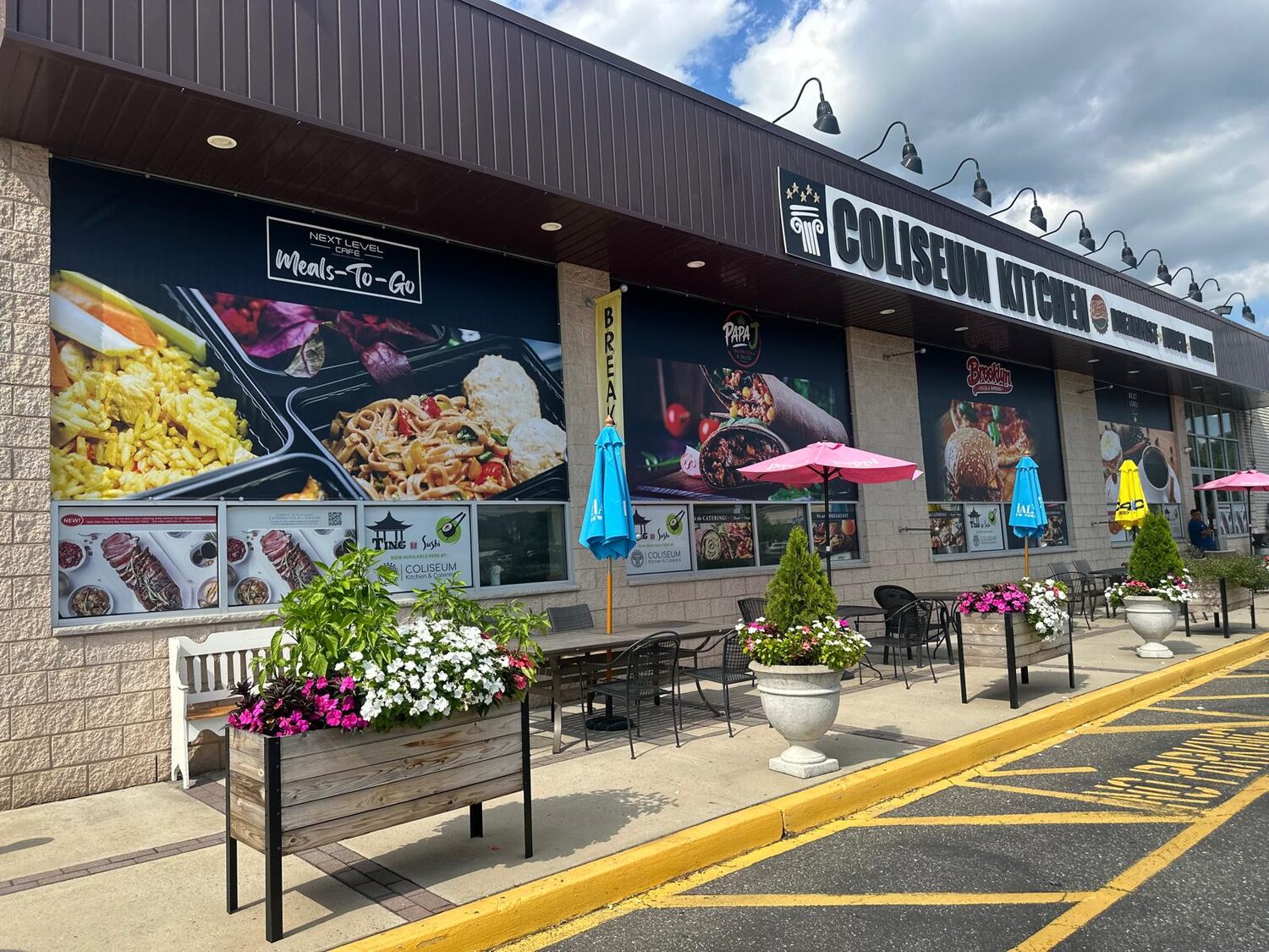 Printed menu panels along the storefront for Coliseum Kitchen